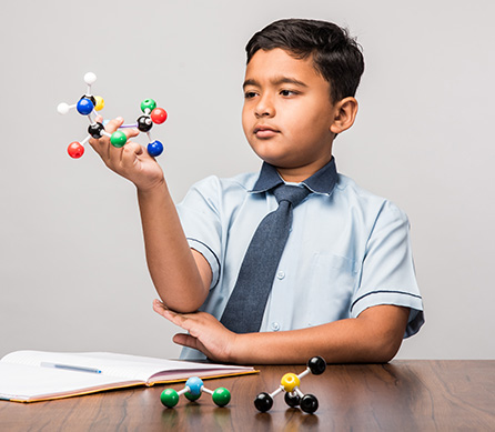 student holding a science model for his gifted and talented test